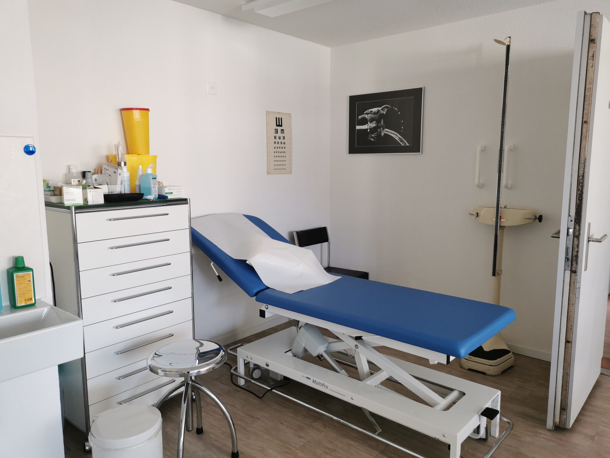 Ein Patientenzimmer mit einem blau-weissen Bett.